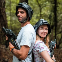 ragazzo e ragazza con abbigliamento e armi per il laser tag