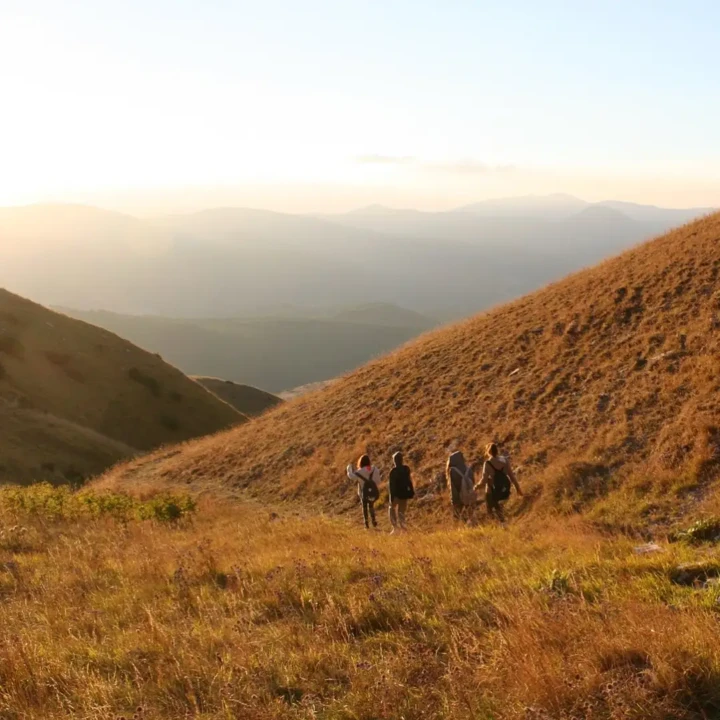 4 ragazza che stanno scendendo dal monte durante un tramonto
