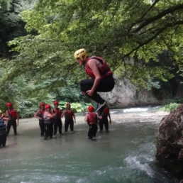 ragazzo che si tuffa a bomba da una roccia, sul fiume Corno