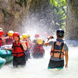 ragazze allegre che giocano con l'acqua durante una sosta di rafting
